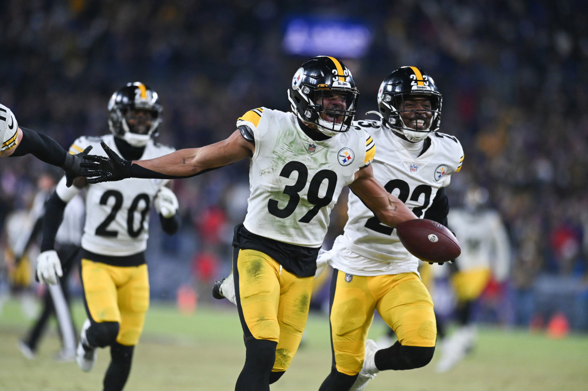 Steelers safety Minkah Fitzpatrick runs with his arms out wide holding the ball